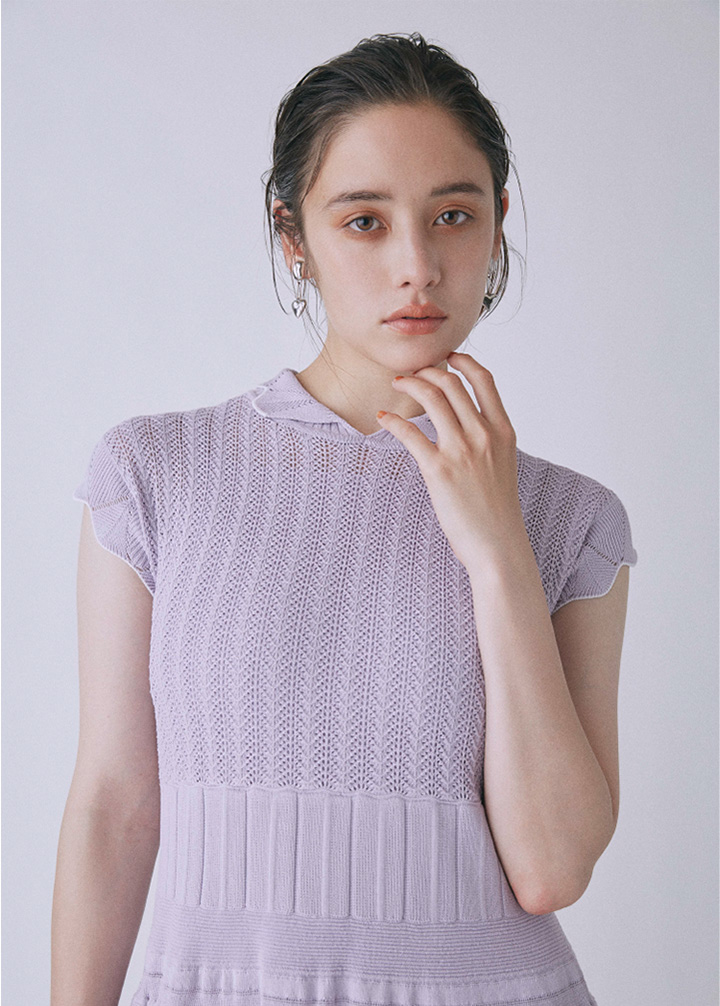 紫のニットドレスを着た女性モデル