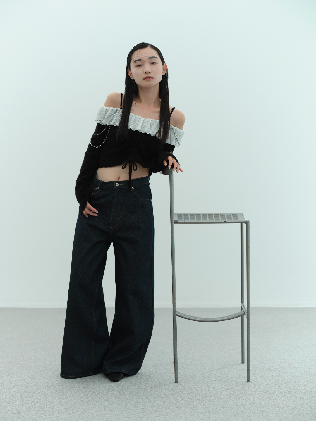 オフショルフリルプルオーバー・リボンステッチデニムパンツ・パールチェーンショルダーネックレス・【WEB限定カラー】ファーハンドルハートバッグ・ダブルストラップバブーシュを着用した女性