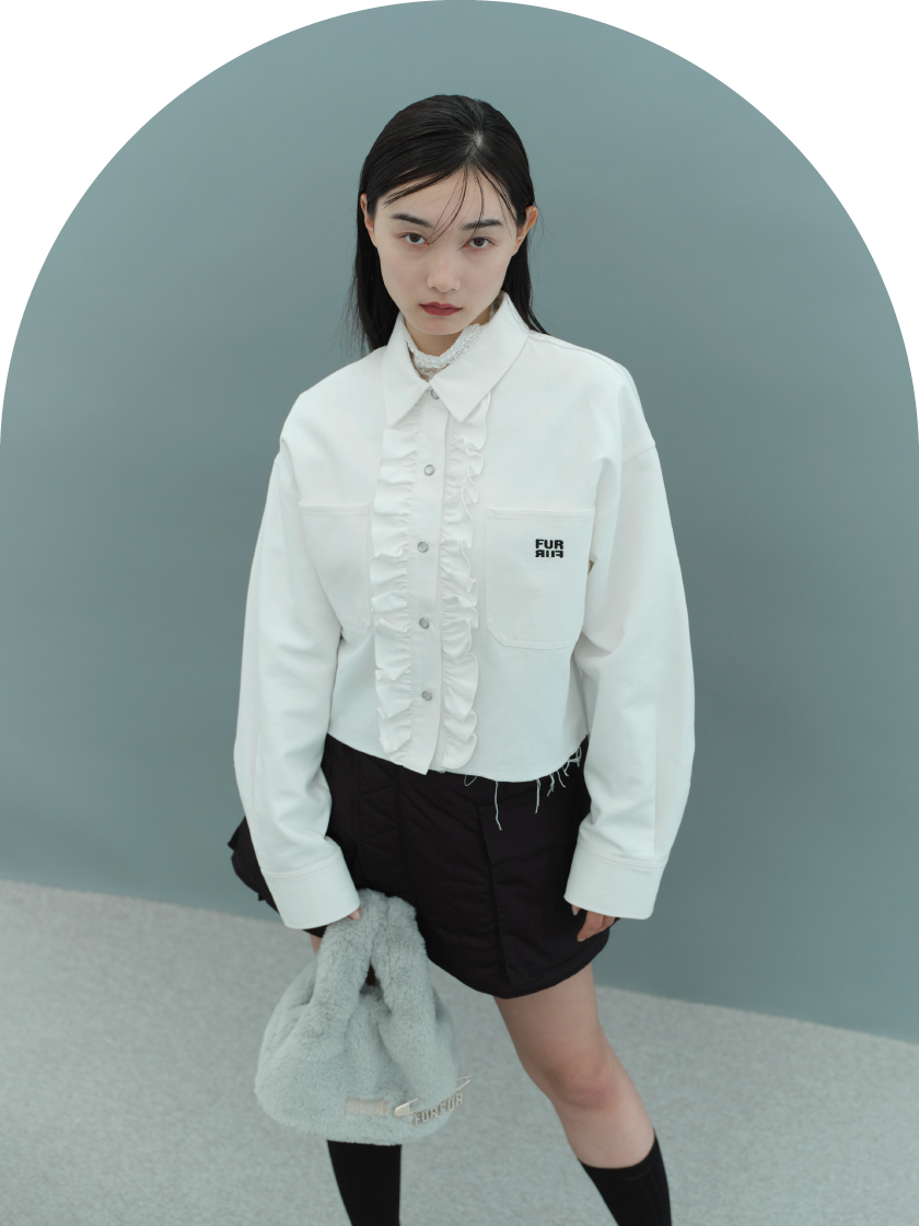 ハイネックレースプルオーバー・ロゴ刺繍クロップドシャツ・パデッドカーゴミニスカート・【限定カラー】エコファーマーケットバッグ・レッグウォーマーを着用した女性