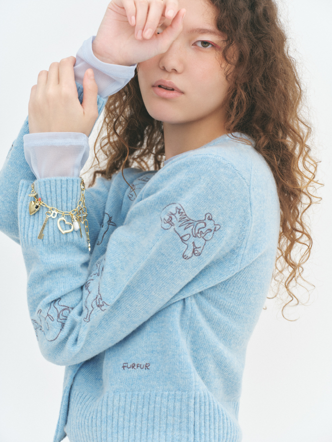 【動物占い®コラボ】アニマル刺繍カーディガンとラッキーモチーフミックスブレスレットを着用した女性