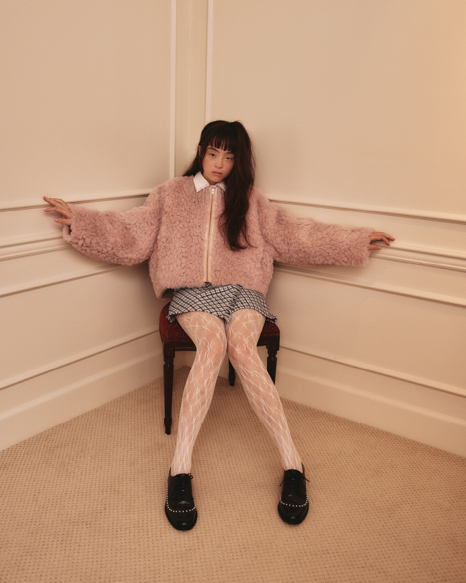 【WEB・一部店舗限定カラー】リバーシブルエコファーブルゾン・ビジューフリンジシャツ・ロービングチェックスカショーパン・レースタイツ・パールメンズドレスシューズを着用した女性
