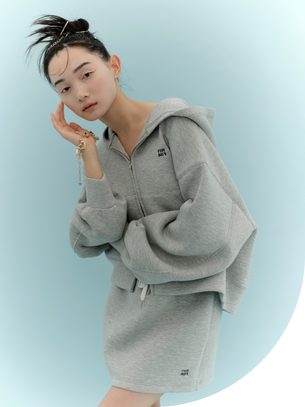 ロゴ刺繍フーディーセットアップ・ロゴヘアピンセット・ラッキーモチーフミックスブレスレット・ダブルストラップバブーシュを着用した女性