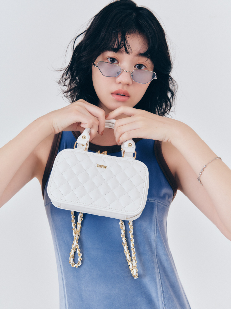 リンガーベロアロングワンピース・アイウェア・ロゴビジューブレスレット・【限定カラー】キルティングフォンホルダーを着用した女性