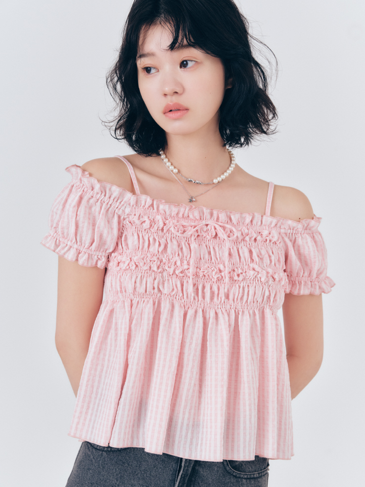 2WAYシャーリングブラウス・フラワー刺繍デニムパンツ・ロゴパールネックレスを着用した女性