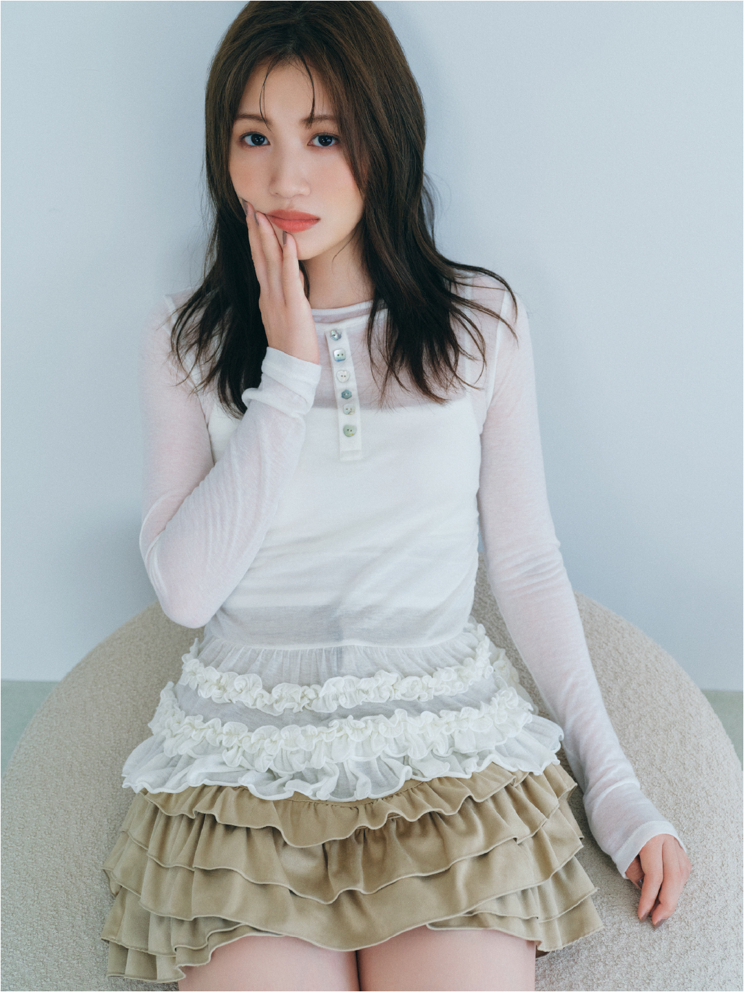 裾フリルジャージートップス・フリルレイヤースウェードショートパンツを着用した女性