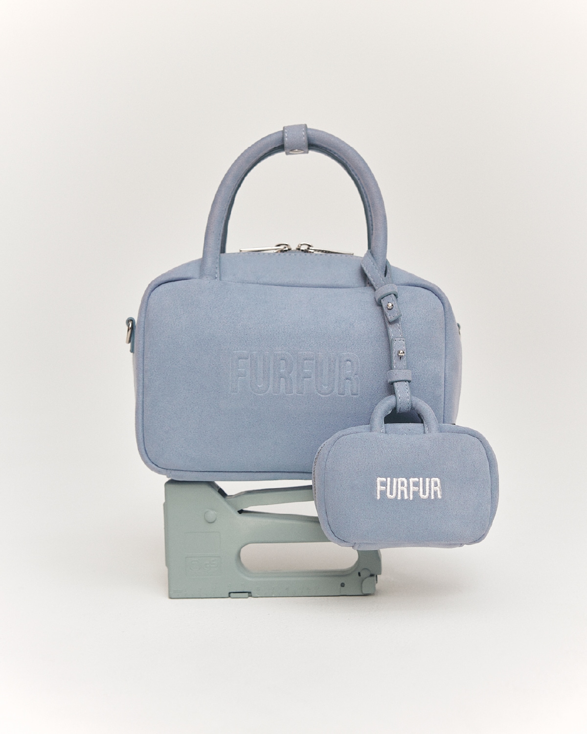 サックスブルーのバッグとチャームの物撮り写真