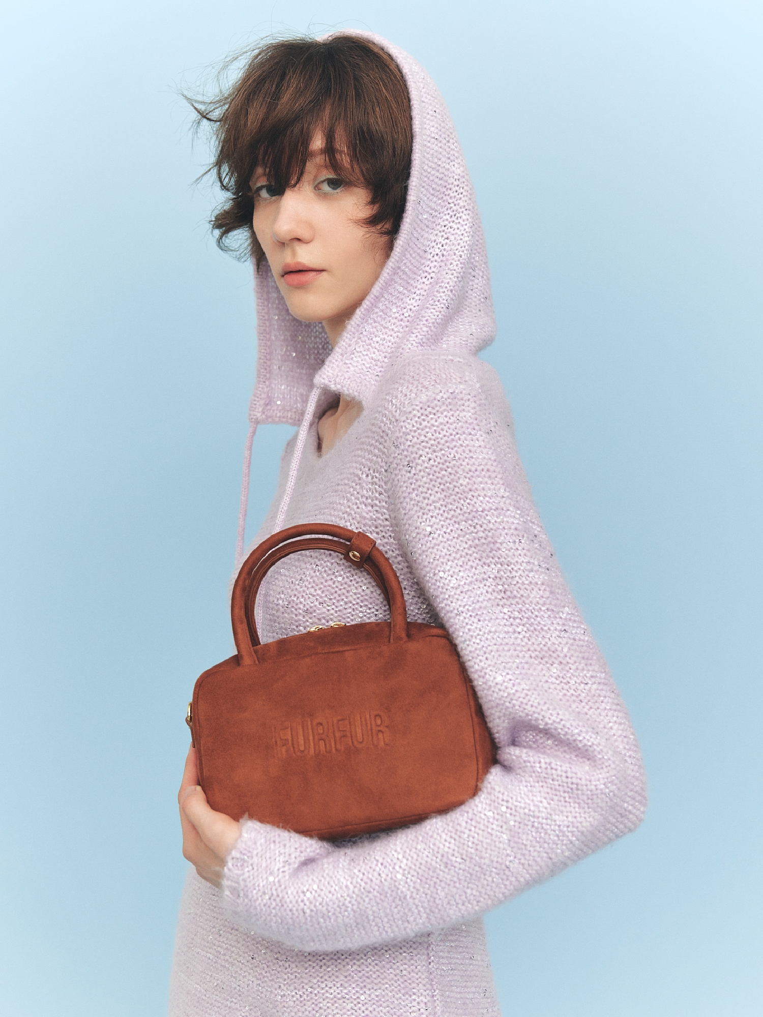 ラベンダーのフード付きワンピースホワイトのチュールスカート・ブラウンのハンドバッグ・黒のブーツの着用例