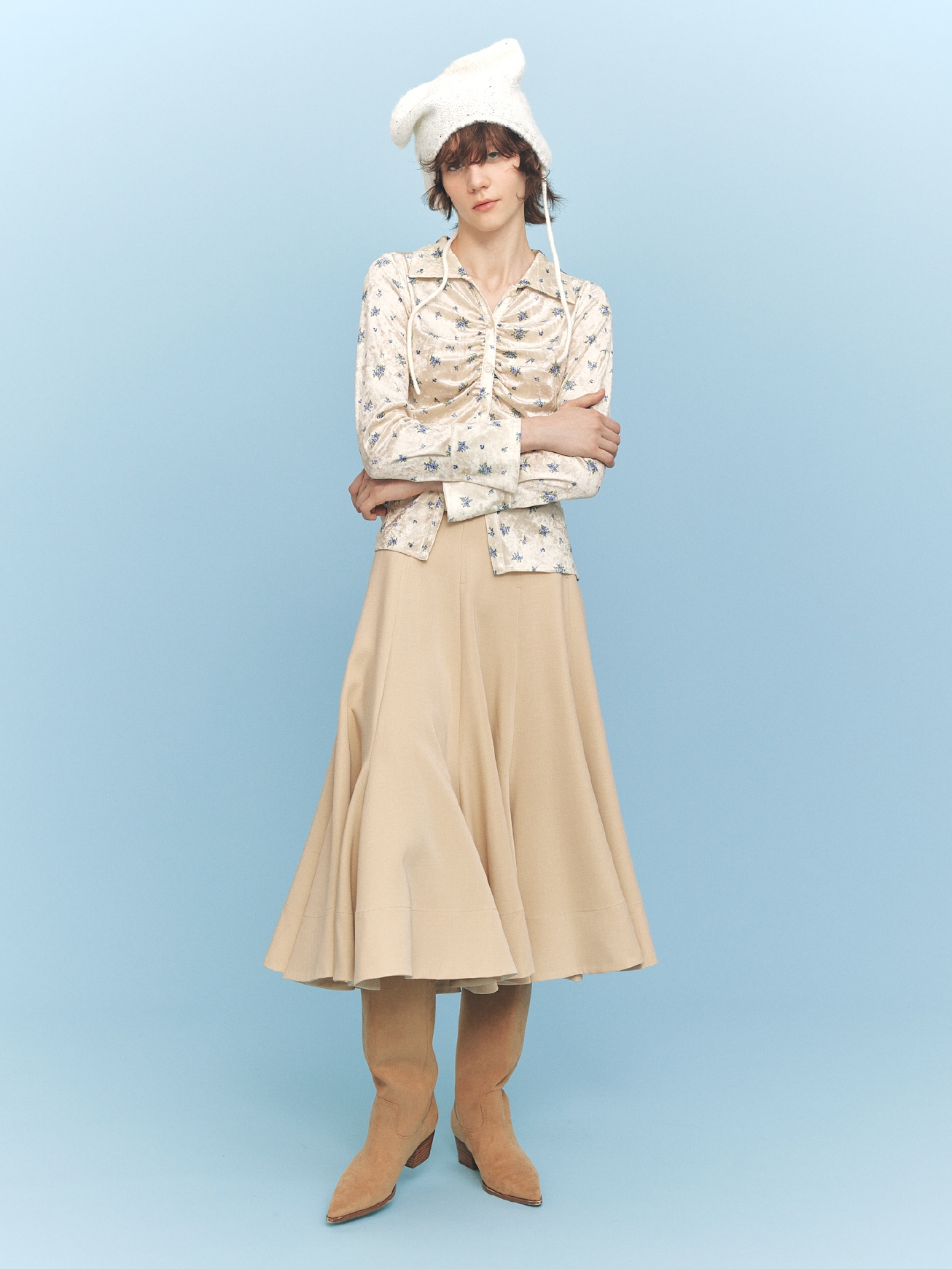 アイボリーの総柄シャツ・ベージュのロングスカート・白の帽子・ベージュのブーツの着用例