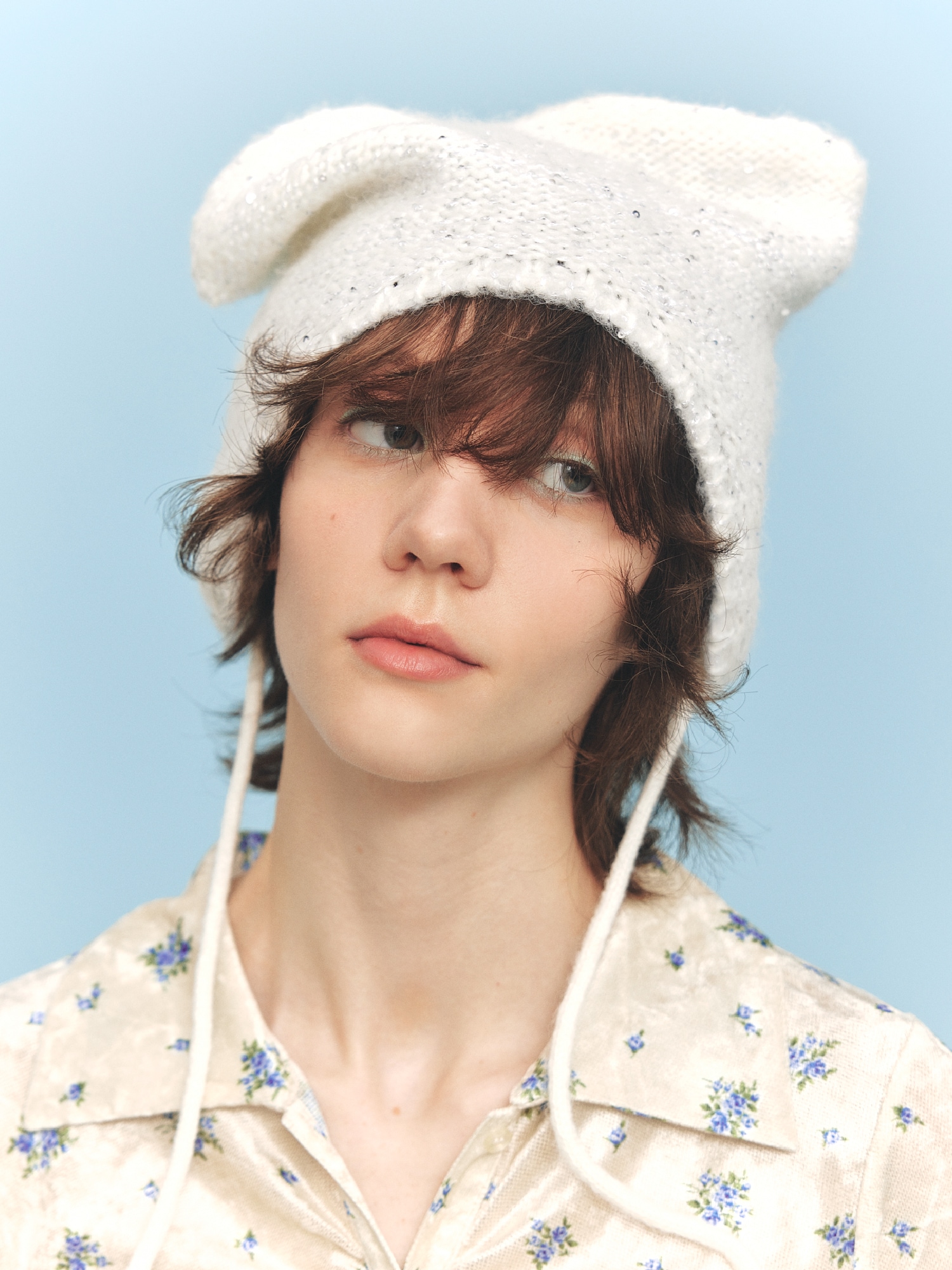 アイボリーの総柄シャツ・ベージュのロングスカート・白の帽子・ベージュのブーツの着用例