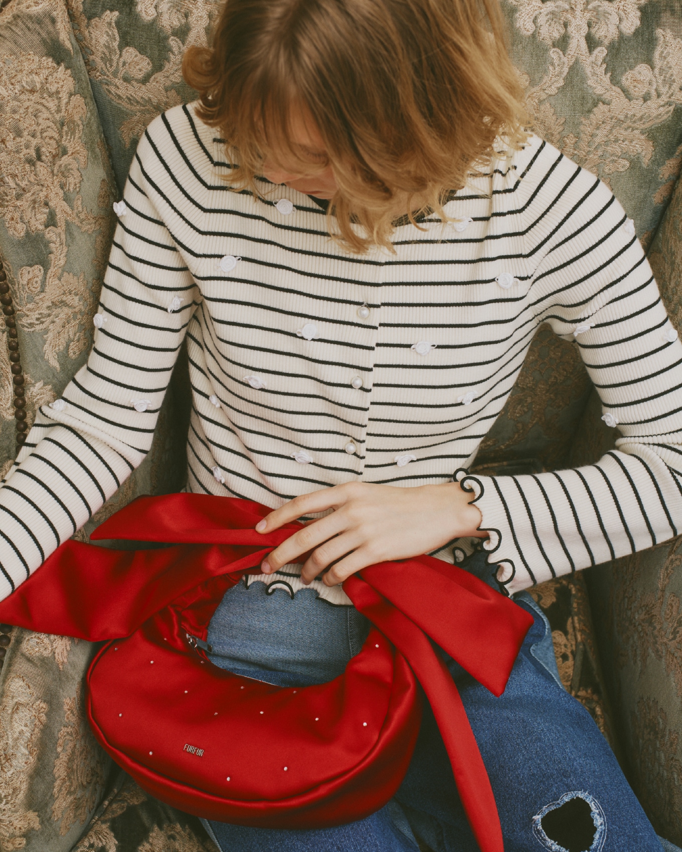 白のプティフラワーボーダーカーディガン・パッチワークデニムパンツ・赤のリボンハンドルサテンムーンバッグ・レイヤードパールネックレス・ブラウンのダブルストラップバブーシュのモデル着用例