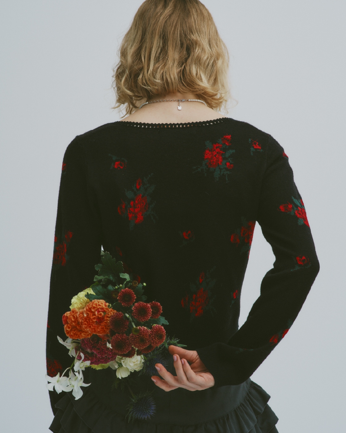 黒のフラワージャガードカーディガン・グレーのフリルレイヤースウェードショートパンツ・リボンモチーフパールネックレス・ウエスタンロングブーツのモデル着用例