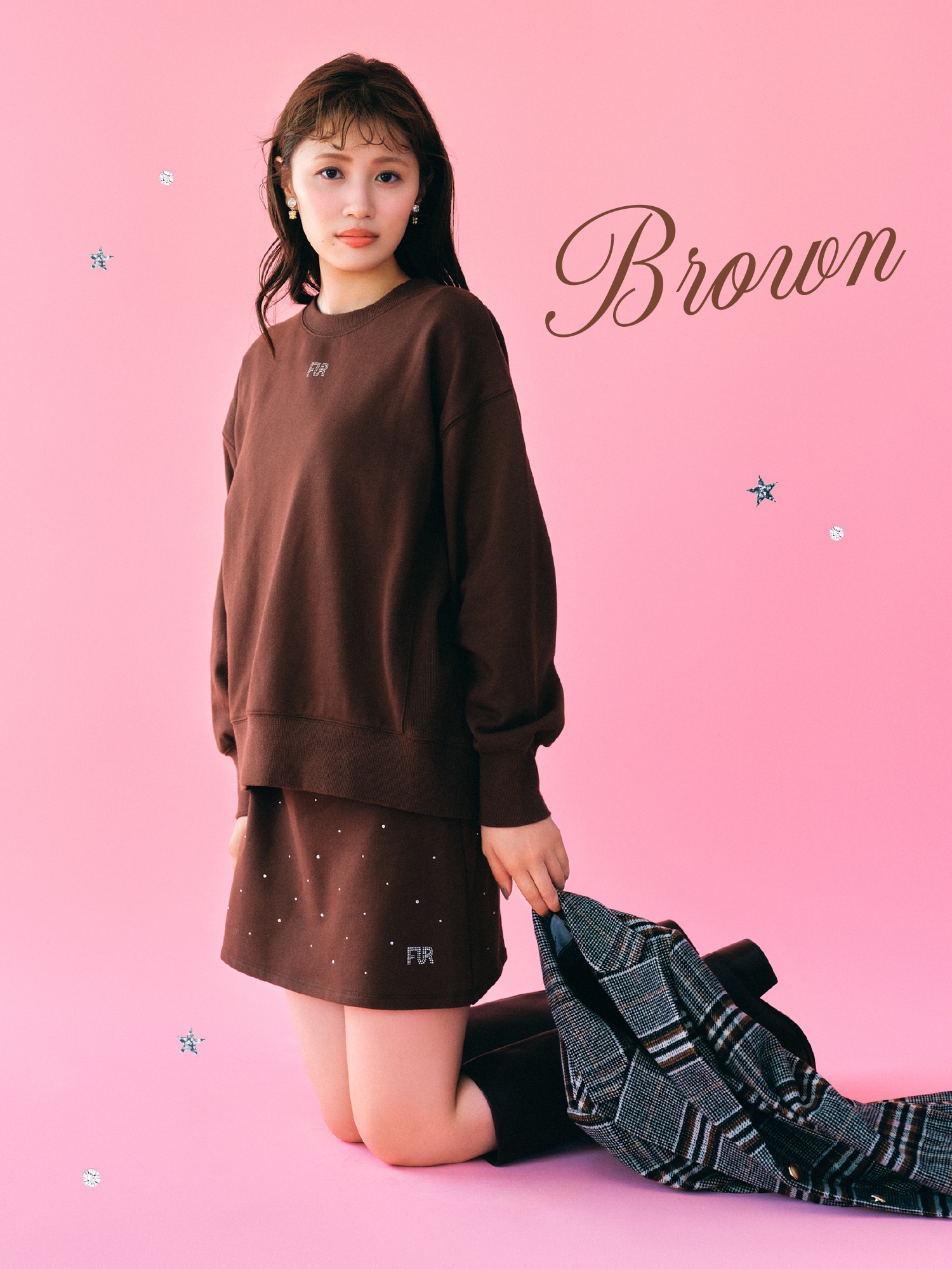 ブラウンのクリスタルロゴスウェットセットアップ・チェック柄のツイードフレアドレスコート・ゴールドのリボンイヤリング・黒のウエスタンロングブーツの着用例1