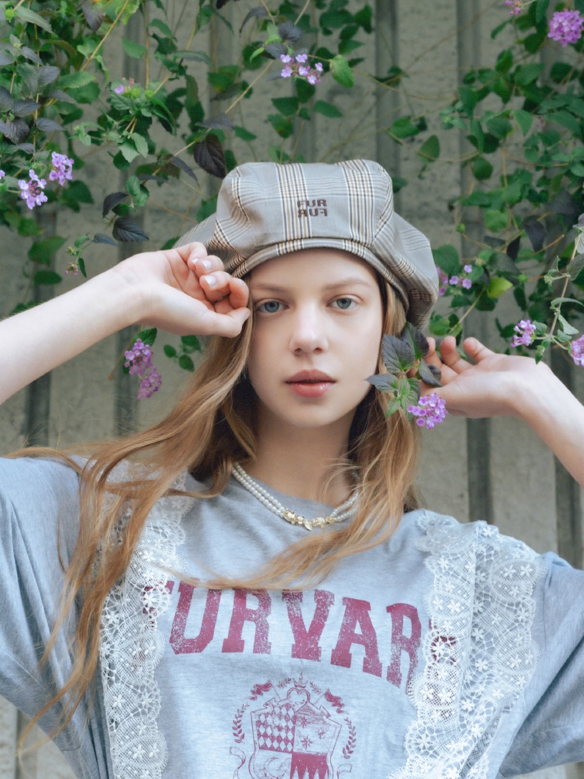 グレーのリメイクデザインレースＴシャツ・黒のスパンコールラップスカート・ブラウンのロゴ刺繍ベレー帽・シルバーのハートショルダーバッグ・ゴールドのフラワーモチーフパールネックレスを合わせたコーディネート