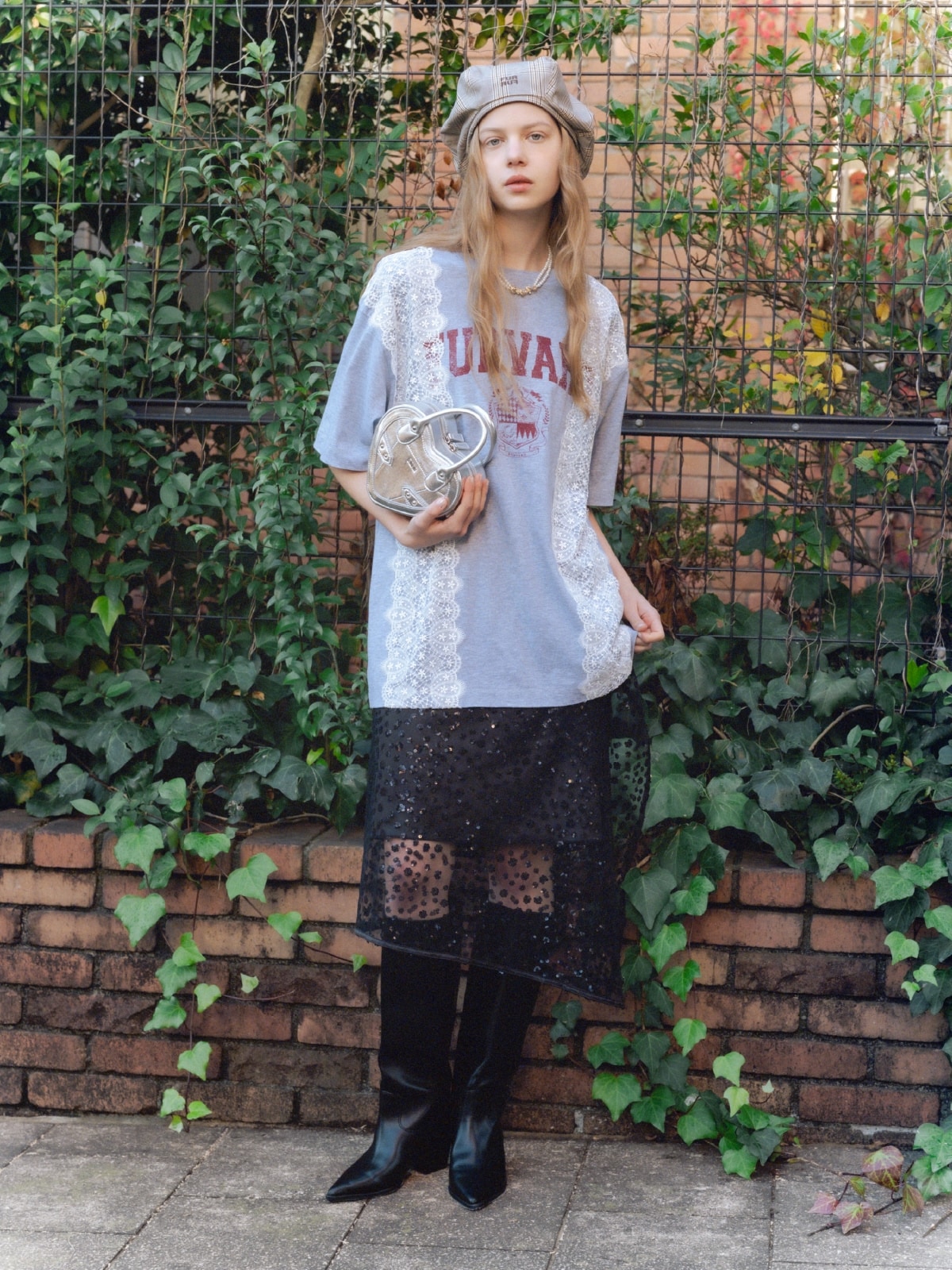 グレーのリメイクデザインレースＴシャツ・黒のスパンコールラップスカート・ブラウンのロゴ刺繍ベレー帽・シルバーのハートショルダーバッグ・ゴールドのフラワーモチーフパールネックレスを合わせたコーディネート