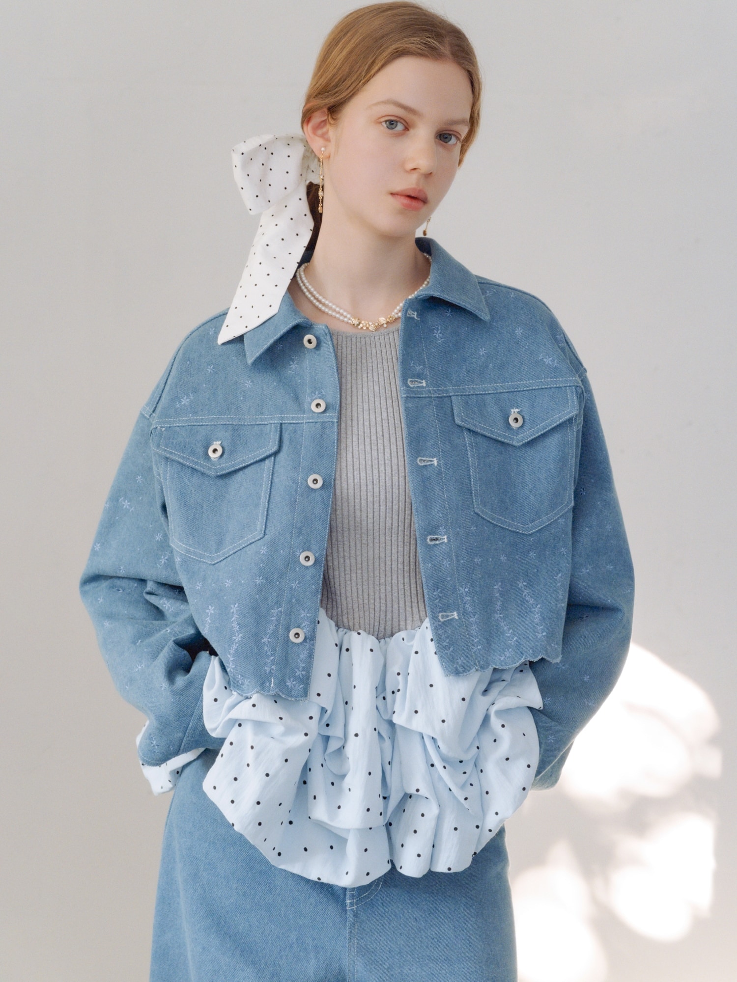 ライトブルーの刺繍クロップドシャツジャケット・ライトブルーのビーズ刺繍デニムパンツ・グレーのバルーンドッキングリブニットプルオーバー・ドットのリボンシュシュ・ゴールドのハートモチーフイヤリング・ゴールドのフラワーモチーフパールネックレス・白のダブルストラップバブーシュを合わせたコーディネート