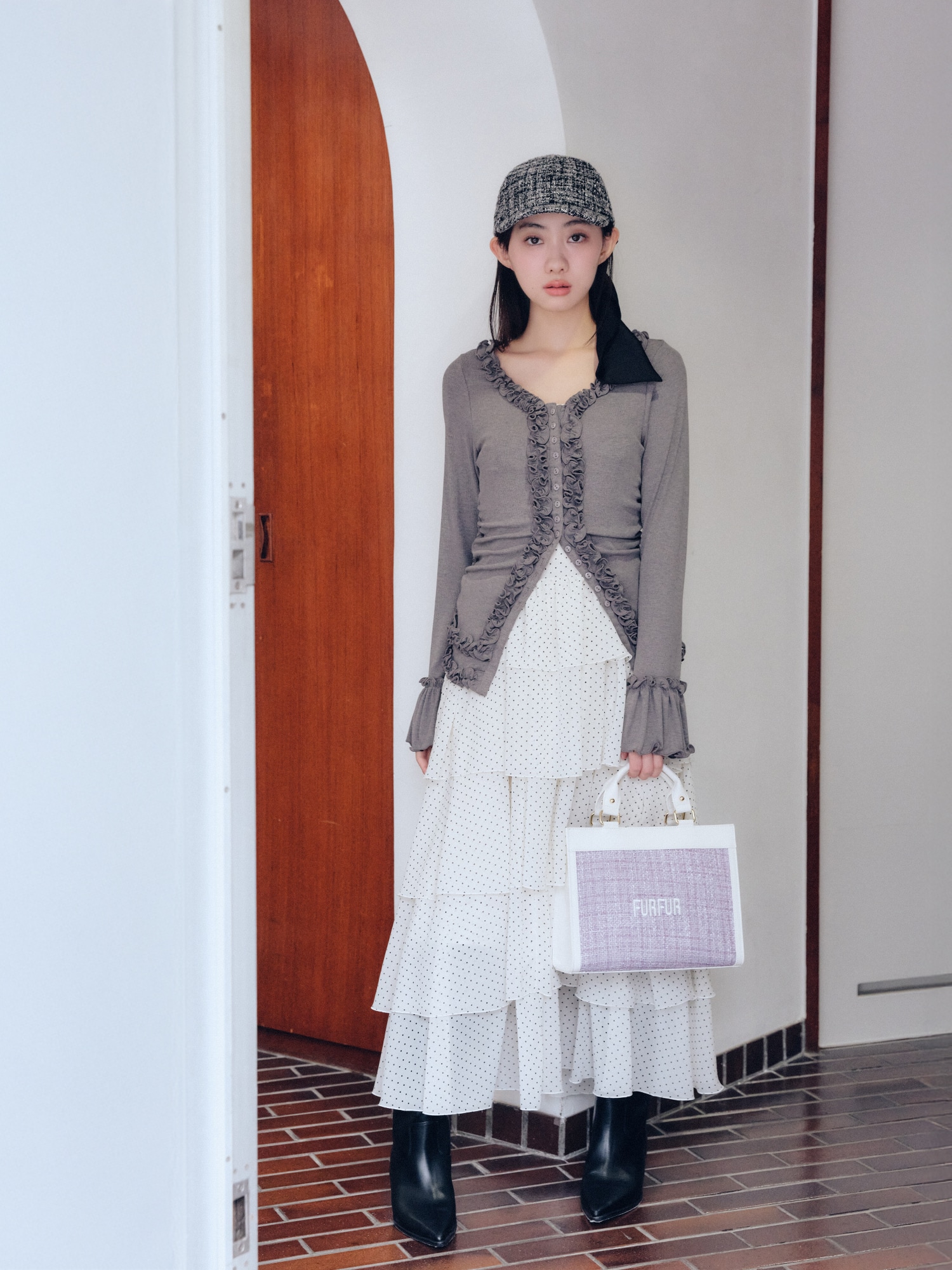グレーのフリルカーディガン・ドットのケープセットティアードドレス・ラベンダーのツイードロゴトートバッグ・黒のツイード×サテンビッグリボンキャップを合わせたコーディネート