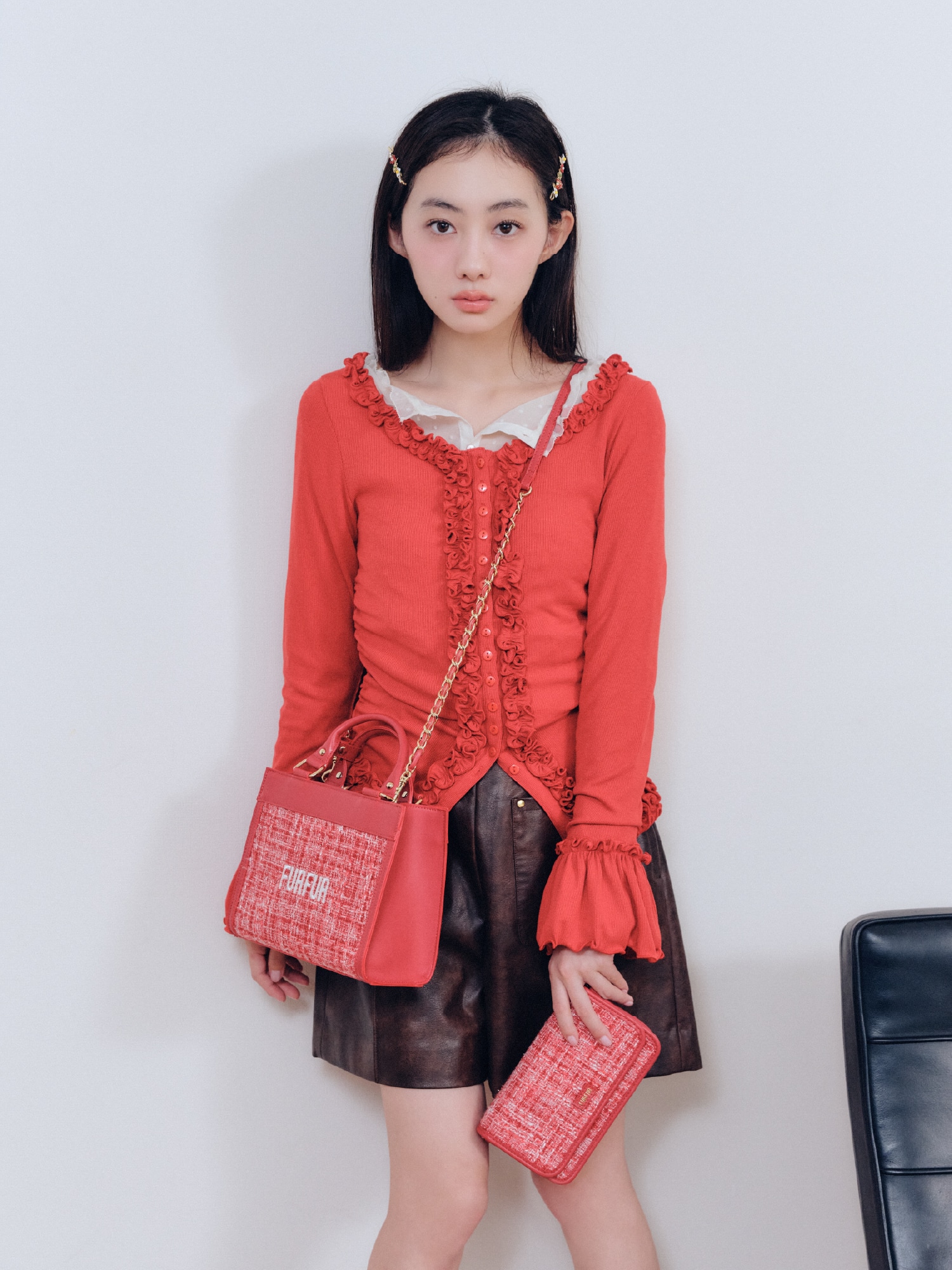 赤のフリルカーディガン・ピンクの２ＷＡＹツイードスタジャン・オフホワイトのレースフリルブラウス・ブラウンのレザーライクショートパンツ・ミックスのフラワーモチーフヘアピンセット・赤のツイードロゴトートバッグ・赤のツイードロゴフォンホルダー・ブラウンのダブルストラップバブーシュを合わせたコーディネート