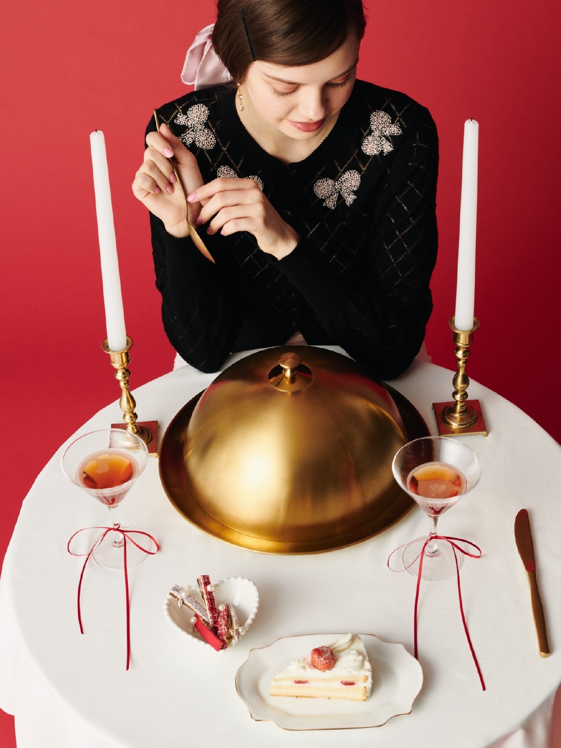 黒のリボンビーズ刺繍アイレットカーディガン・白のフリルチェックチュールスカート・ピンクのリボンシュシュ・白のハートモチーフイヤリングを合わせた、甘めのディテールが大人可愛いムードを添えるコーディネート