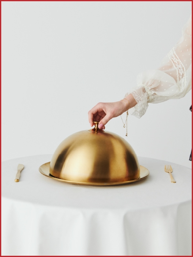 金のクローシュ（蓋）を開けようとしている写真