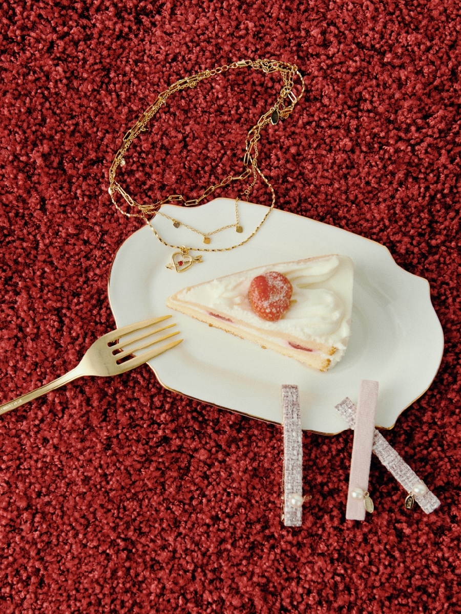 イチゴのショートケーキ皿にあしらわれたゴールドのハートモチーフ３連ネックレスとピンクのツイード×ベロアヘアクリップセット商品写真