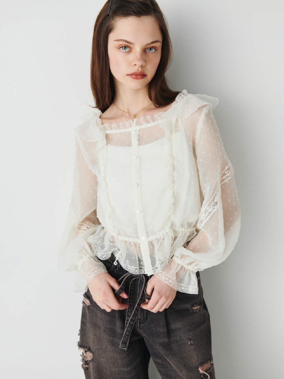 オフホワイトのレースフリルブラウス・黒のレースクラッシュデニムパンツ・ゴールドのハートモチーフネックレスを合わせた、甘めのディテールが大人可愛いムードを添えるコーディネート