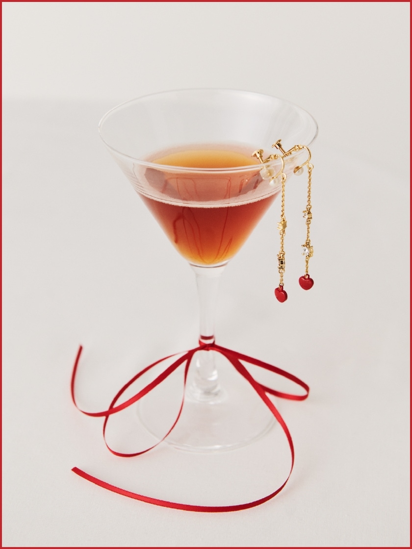 シャンパングラスに添えられた赤のハートモチーフイヤリング商品写真