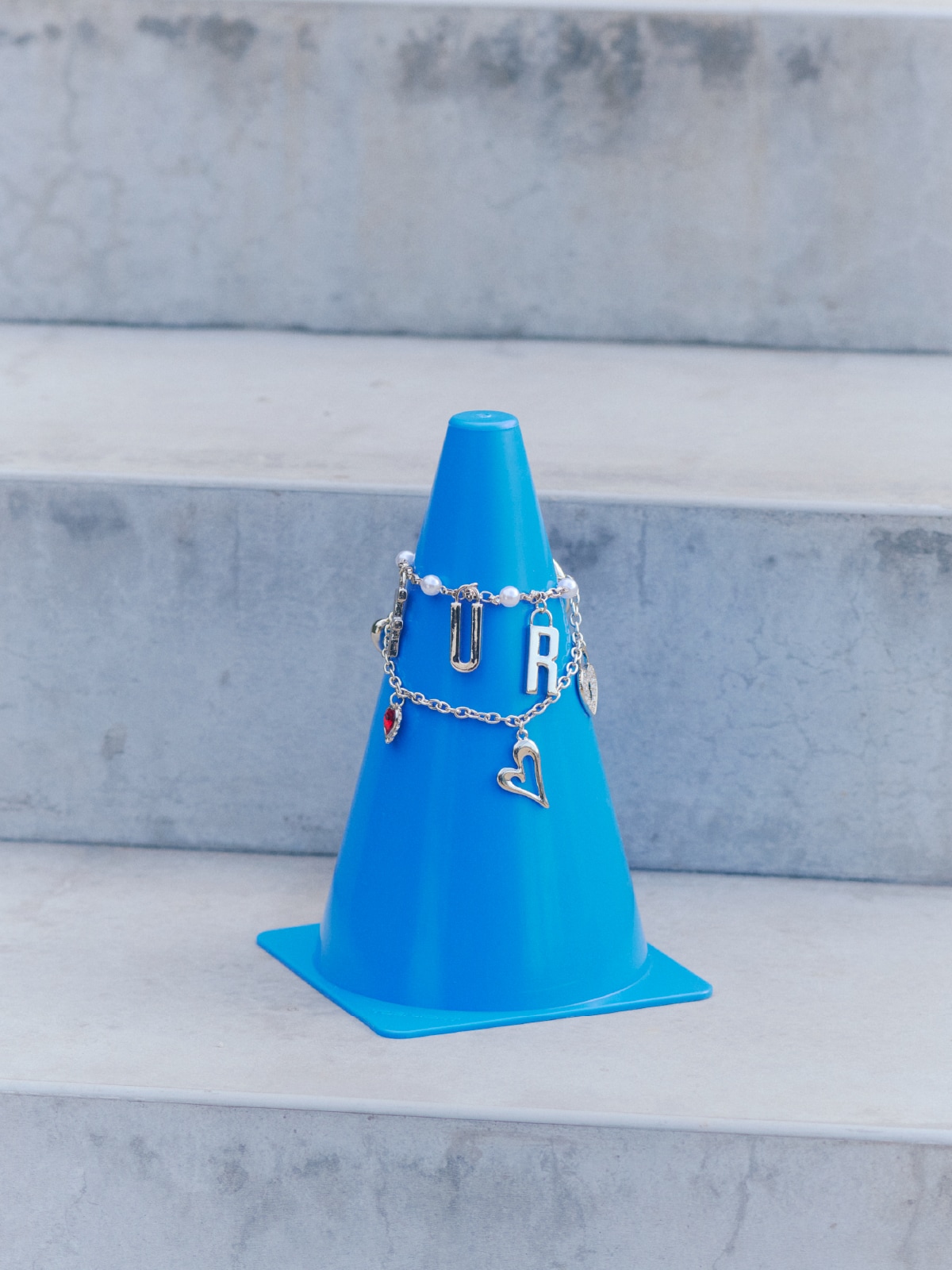 三角コーンに掛けられたチャームの商品写真。