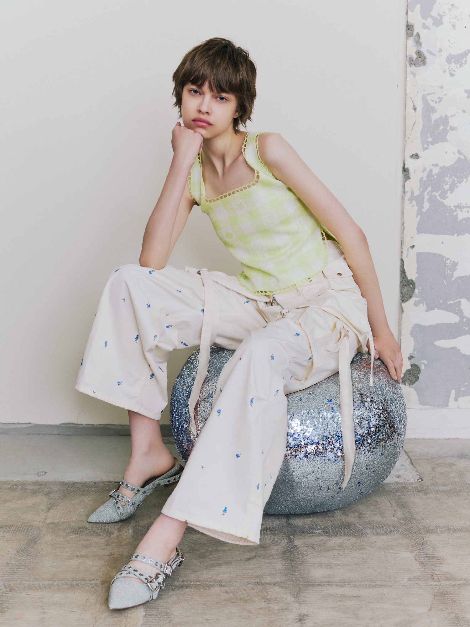 ライムのタンクトップにアイボリーのスカートとアイボリーのパンツを合わせ、ミントのシューズを取り入れたコーディネート。