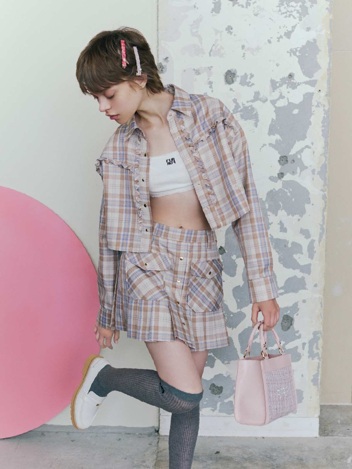 ベージュのチェックのシャツとスカートを合わせ、レッドとピンクのヘアピンセット、ピンクのバッグ、グレーのソックス、オフホワイトのシューズを取り入れたコーディネート。