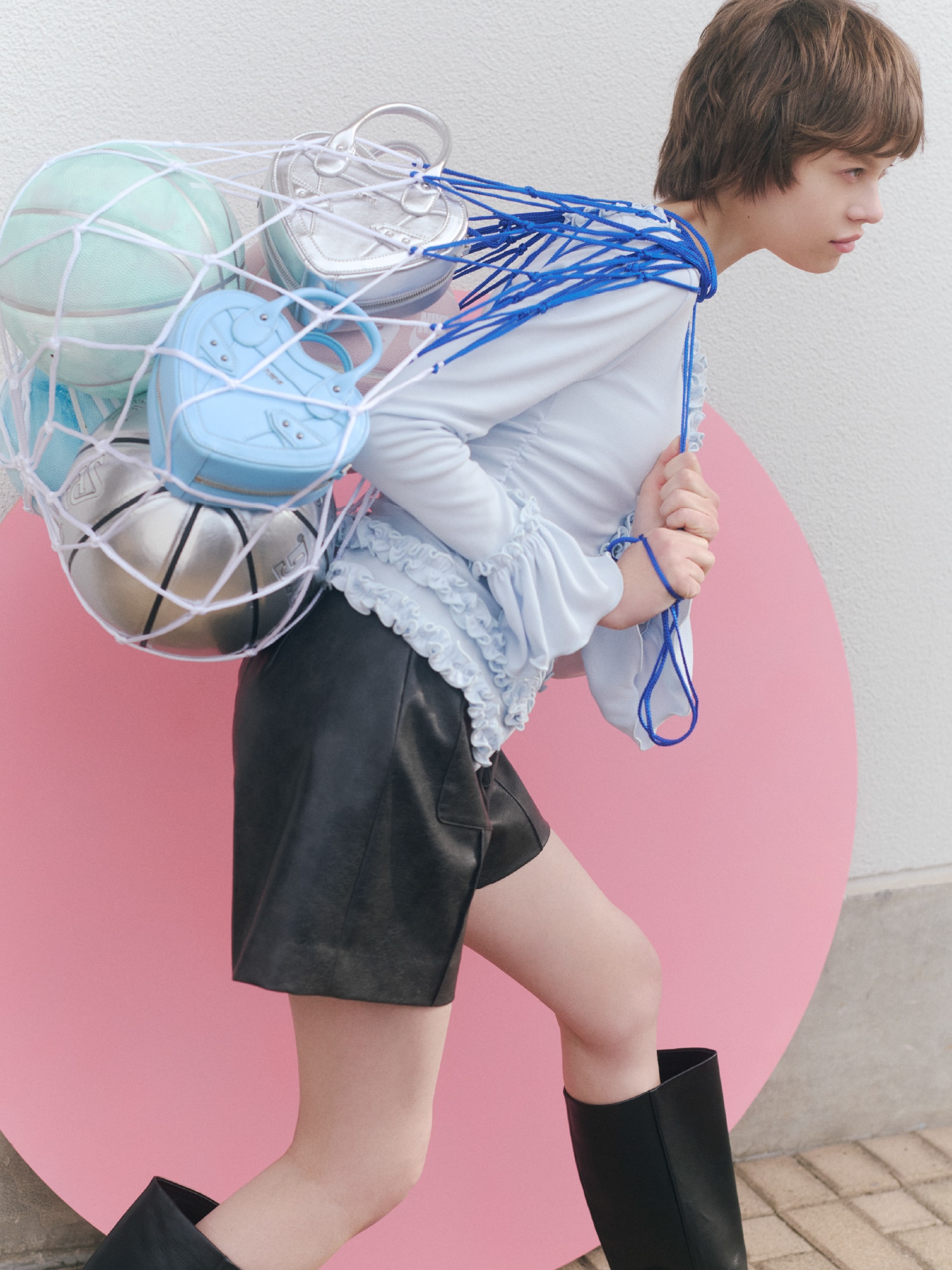 ライトブルーのカーディガンにブラックのパンツを合わせ、シルバーのバッグを取り入れたコーディネート。