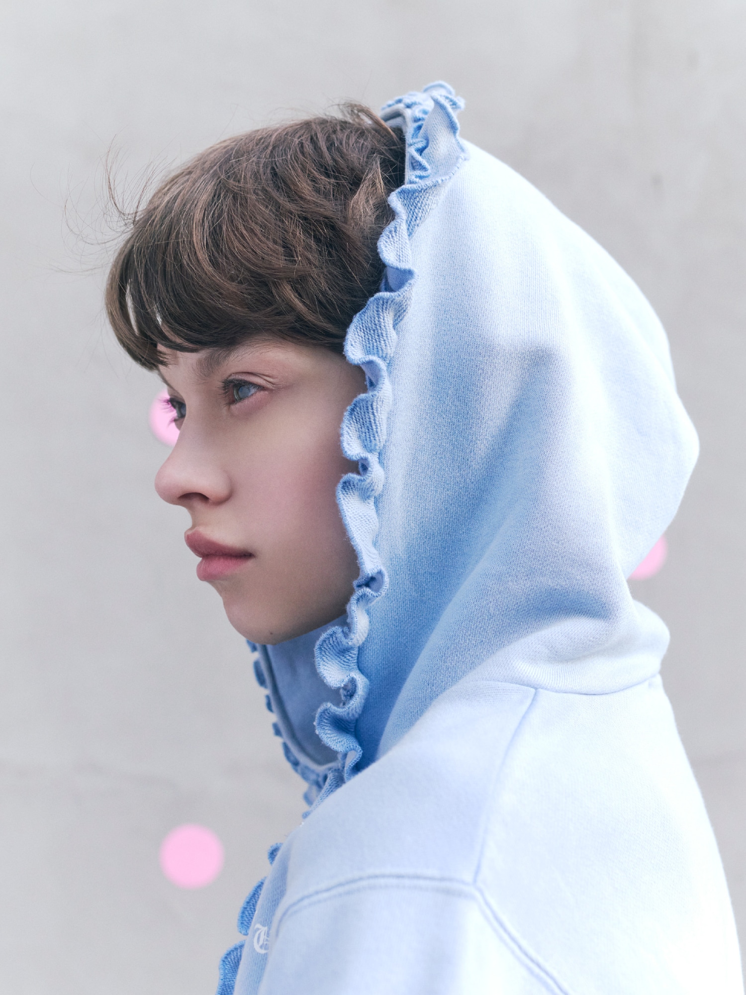 ブルーのフーディーの上半身写真