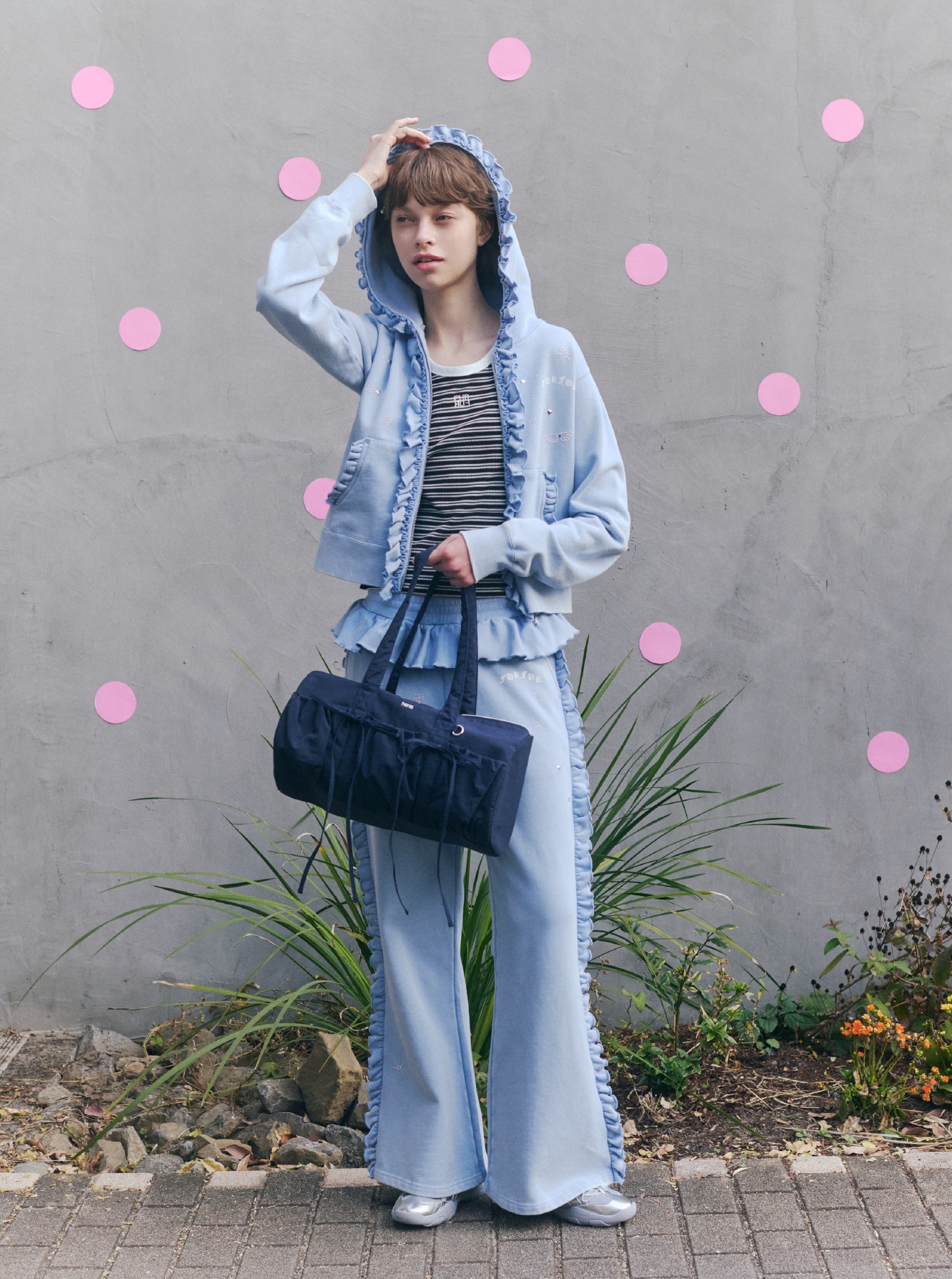 ブルーのフーディーとブルーのパンツ、ブラックのタンクトップを合わせ、ネイビーのバッグとシルバーのシューズを取り入れたコーディネート。