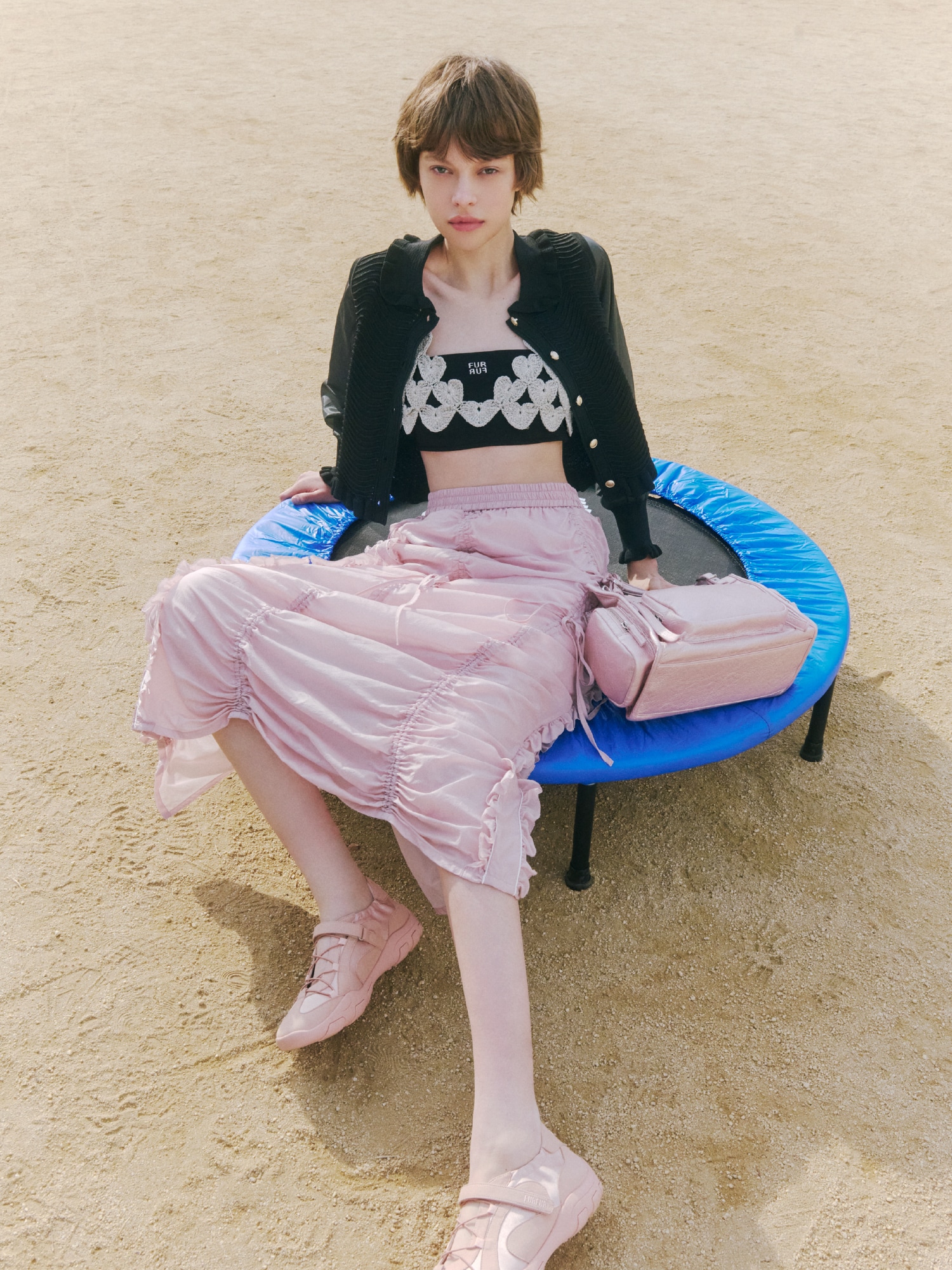 ブラックのカーディガンとシルバーのビスチェ、ブラックのブラトップにピンクのスカートを合わせ、ピンクのバッグとピンクのシューズを取り入れたコーディネート。