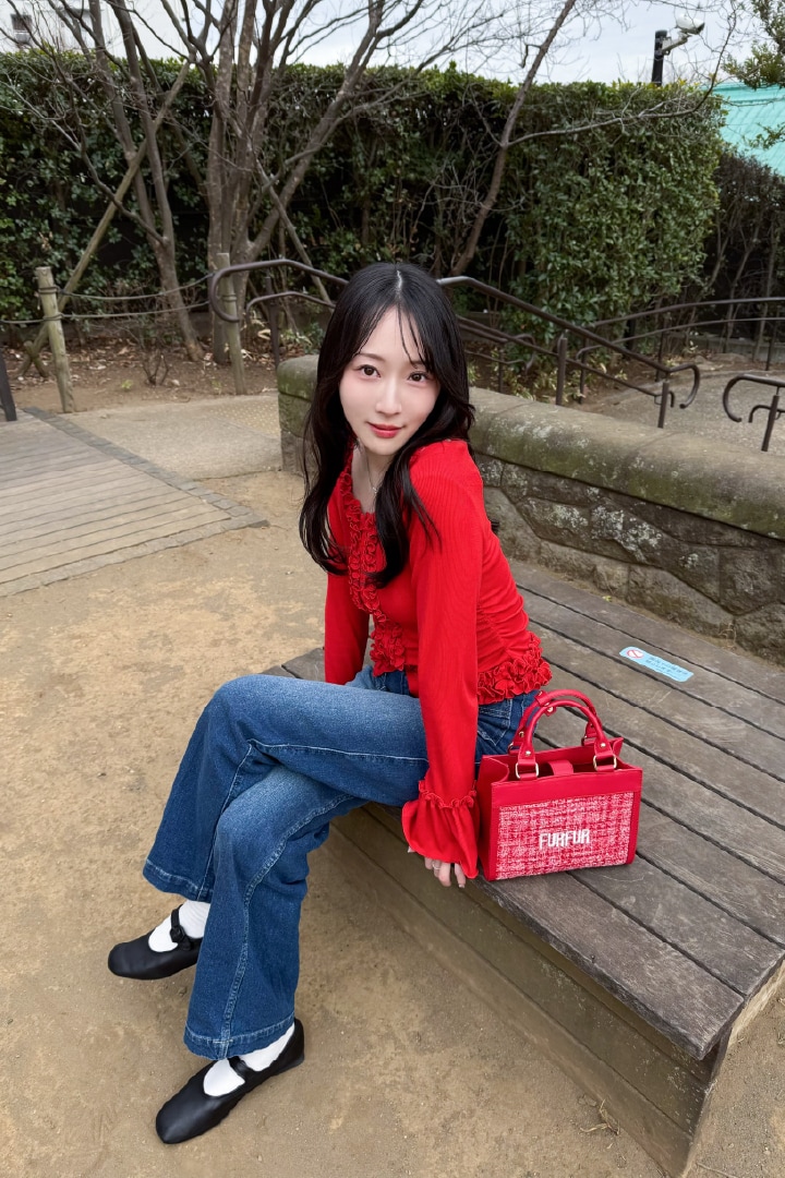 赤のツイードロゴトートバッグとフリルカーディガンを合わせたコーディネート