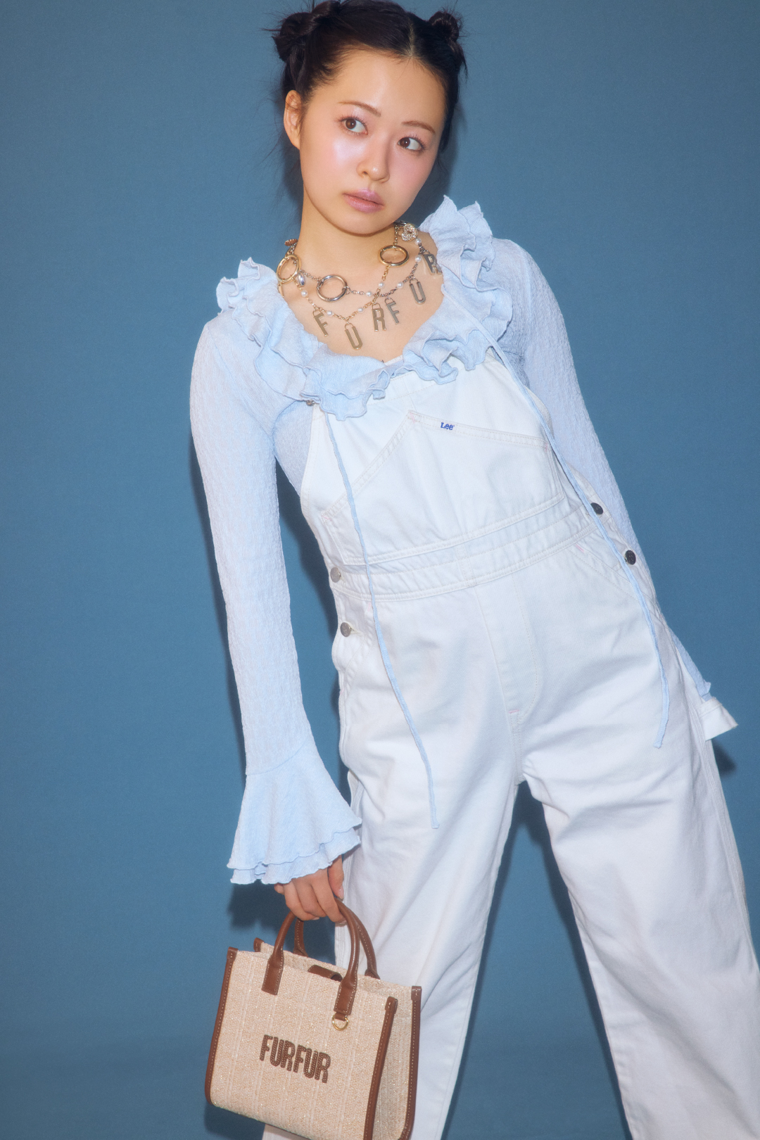 ラッフルフリルプルオーバー・Ｌｅｅコラボデニムオーバーオール・ロゴハートバッグチャーム・ラフィアロゴトートバッグを着用した女性
