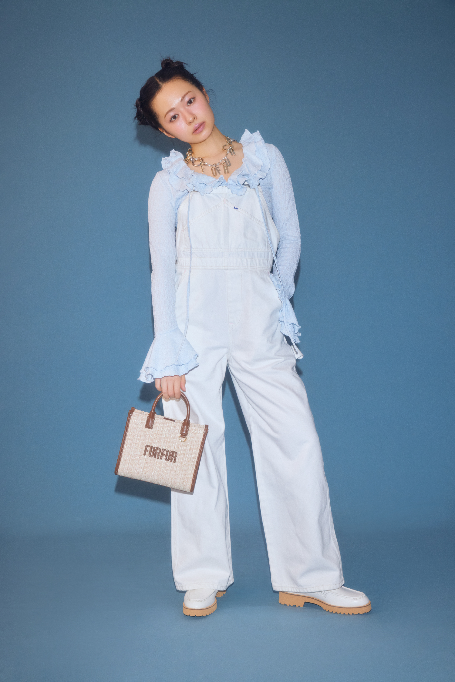 ラッフルフリルプルオーバー・Ｌｅｅコラボデニムオーバーオール・ロゴハートバッグチャーム・ラフィアロゴトートバッグ・ミニリボンカシメローファーを着用した女性