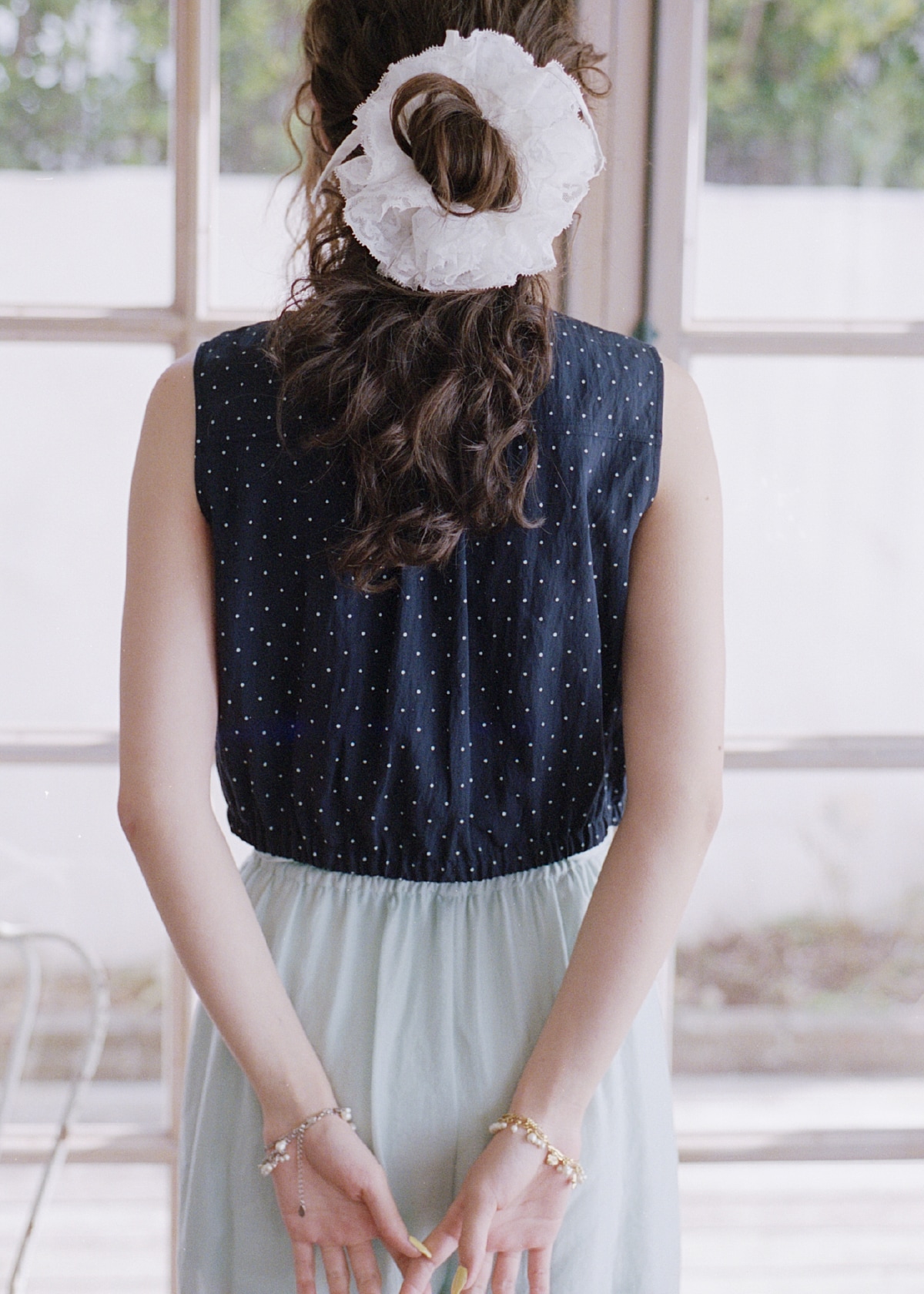 ネイビーのノースリーブフリルブラウス・ミントのドロストパンツ・白のバレリーナシュシュ・ブレスレットを合わせたコーディネート