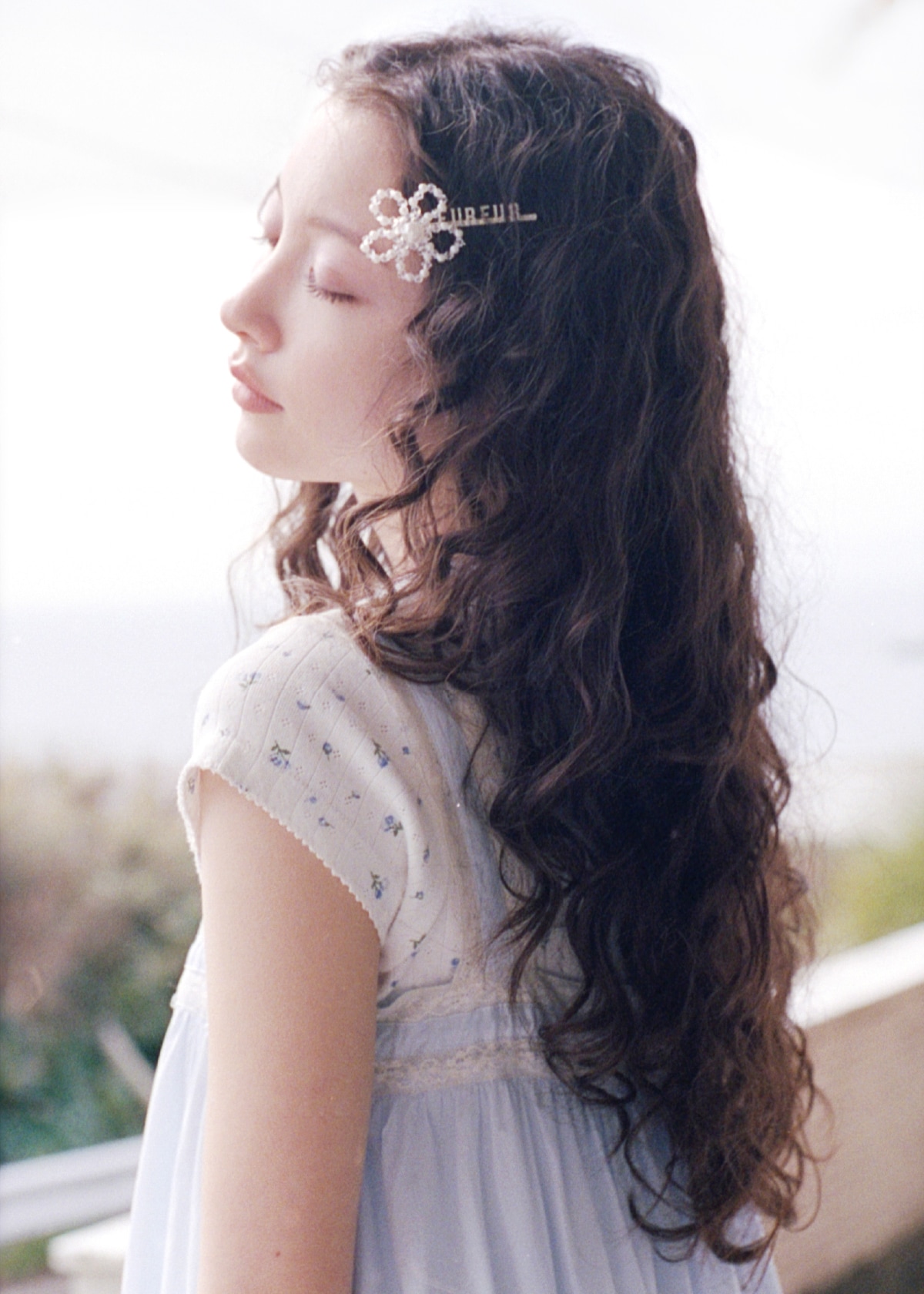 ライトブルーのレースデザインチュニックワンピース・白のレースワッペンTシャツ・ブラウンのバッグ・ピンクのネックレス・ヘアピンセットを合わせたコーディネート