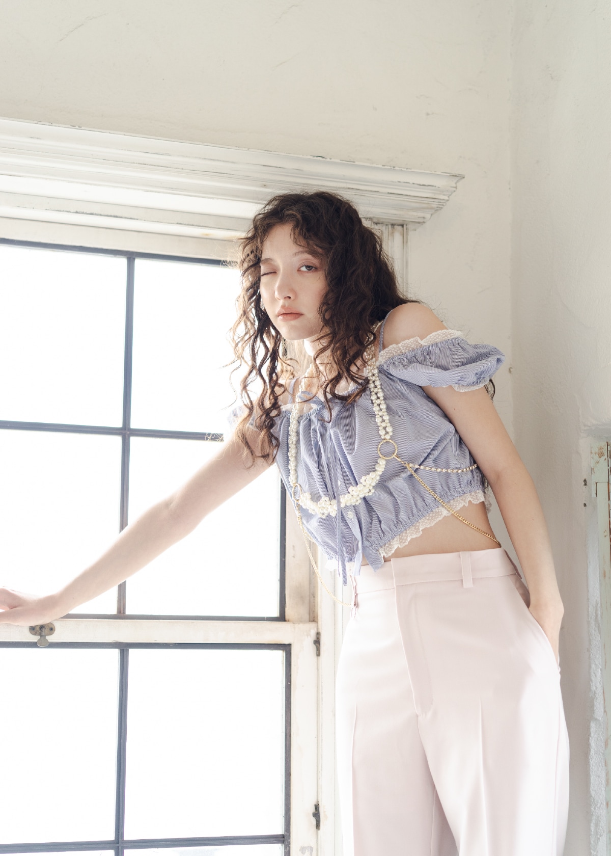 ストライプ柄のパフスリーブギャザーブラウス・ピンクのフレアパンツ・ゴールドのハーネス・黒のサンダル・白のブローチセットを合わせたコーディネート