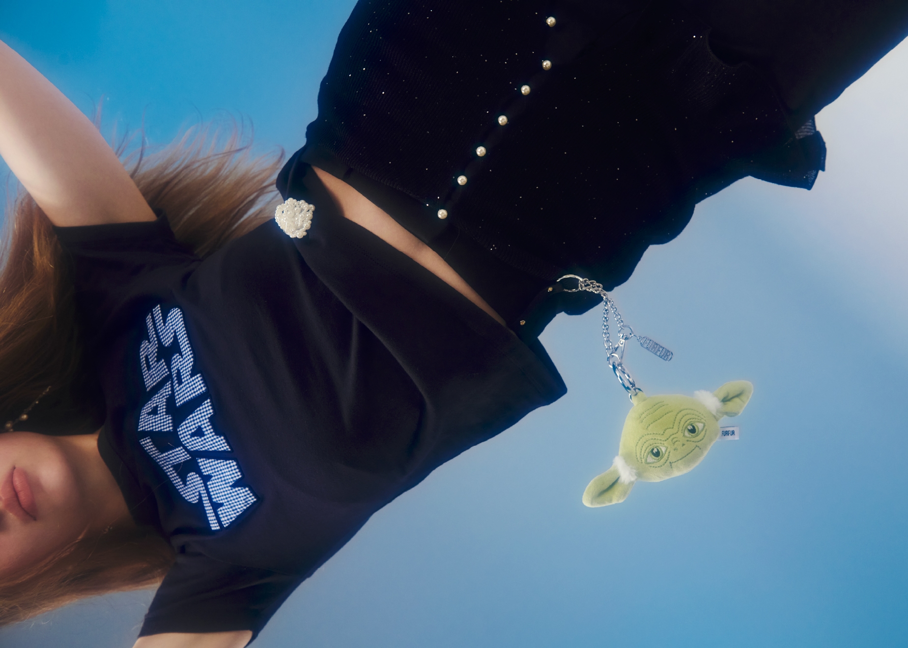 ネイビーのアップリケロゴTシャツ・チャーム・黒のスパンコールシアーリブカーディガンとセンタープレスフレアパンツ・イヤリング・ピンブローチ・シルバーのクロスストラップアイレットシューズを合わせたコーディネート