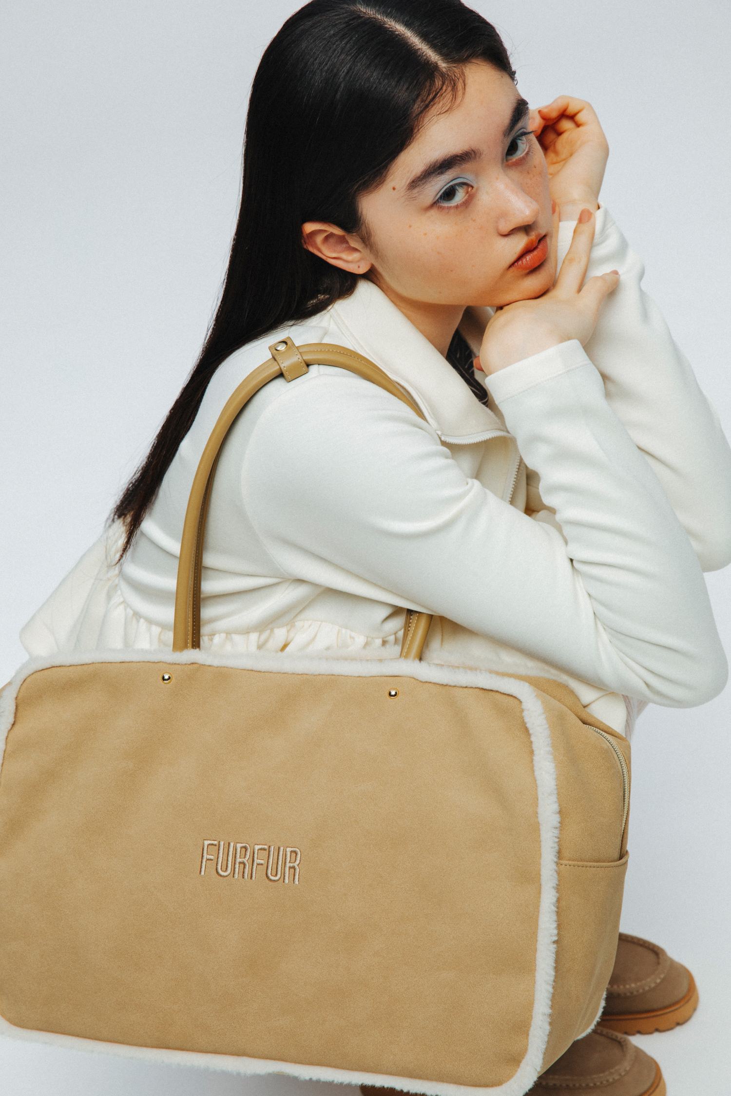 ハーフジップペプラムカットプルオーバー・裾フリルジャージートップス・フラワー刺繍ミニスカート・ムートンBIGボストンバッグ・ロゴシアーソックス・ムートンライクアンクルレースアップブーツを着用した女性
